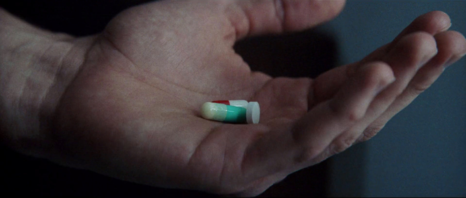 a person holding a pill in their hand