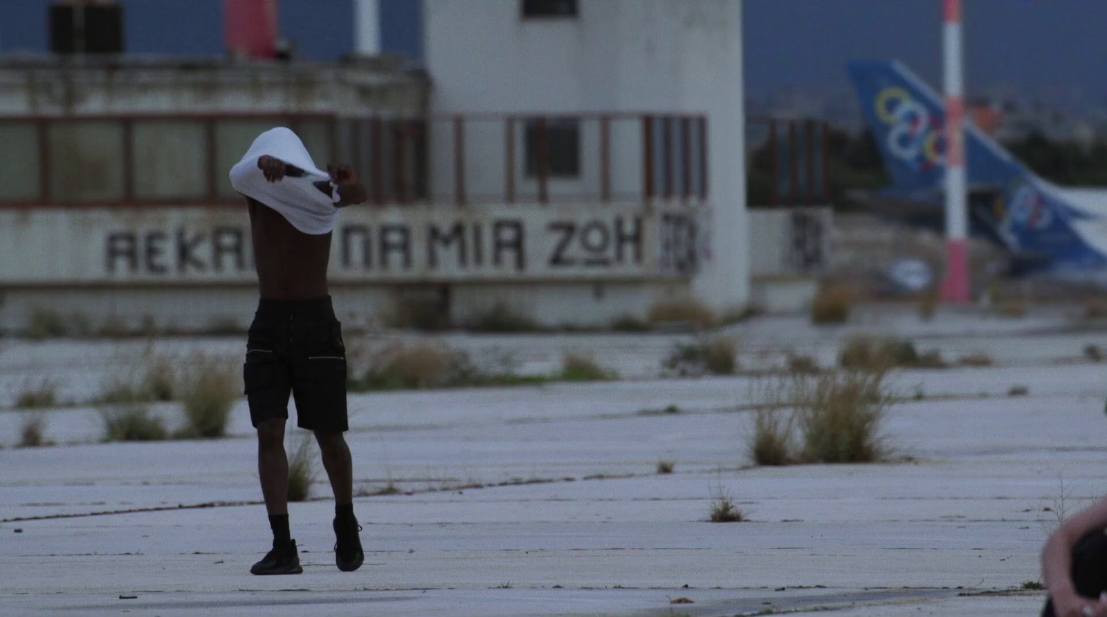 a man in shorts and a hat is flying a kite