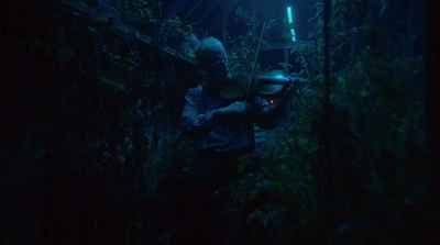 a man in a dark forest holding a flashlight