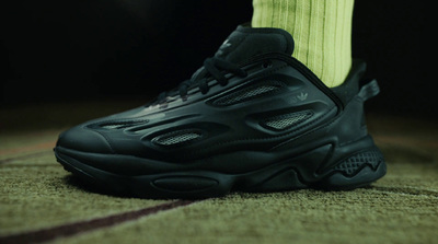 a close up of a person's foot wearing black sneakers