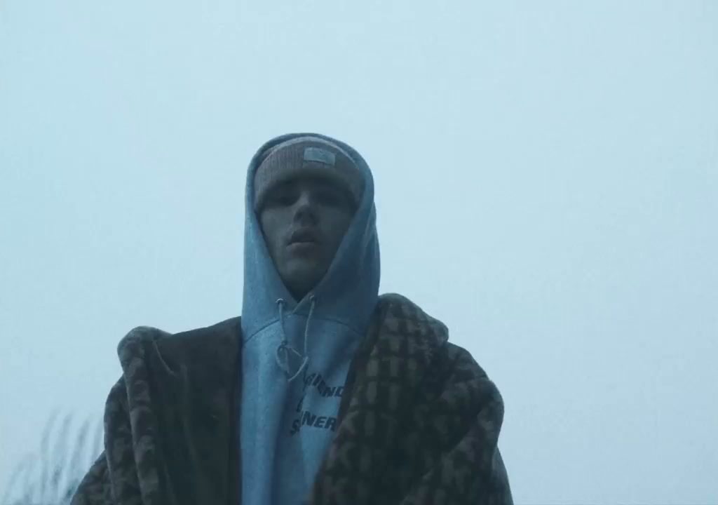 a man in a hooded jacket standing in the rain