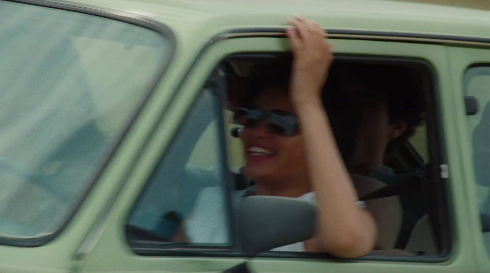 a woman sitting in the driver's seat of a green truck