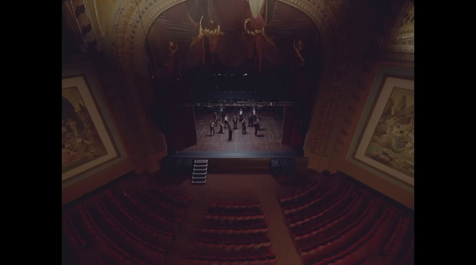 an empty theater with a stage and red seats