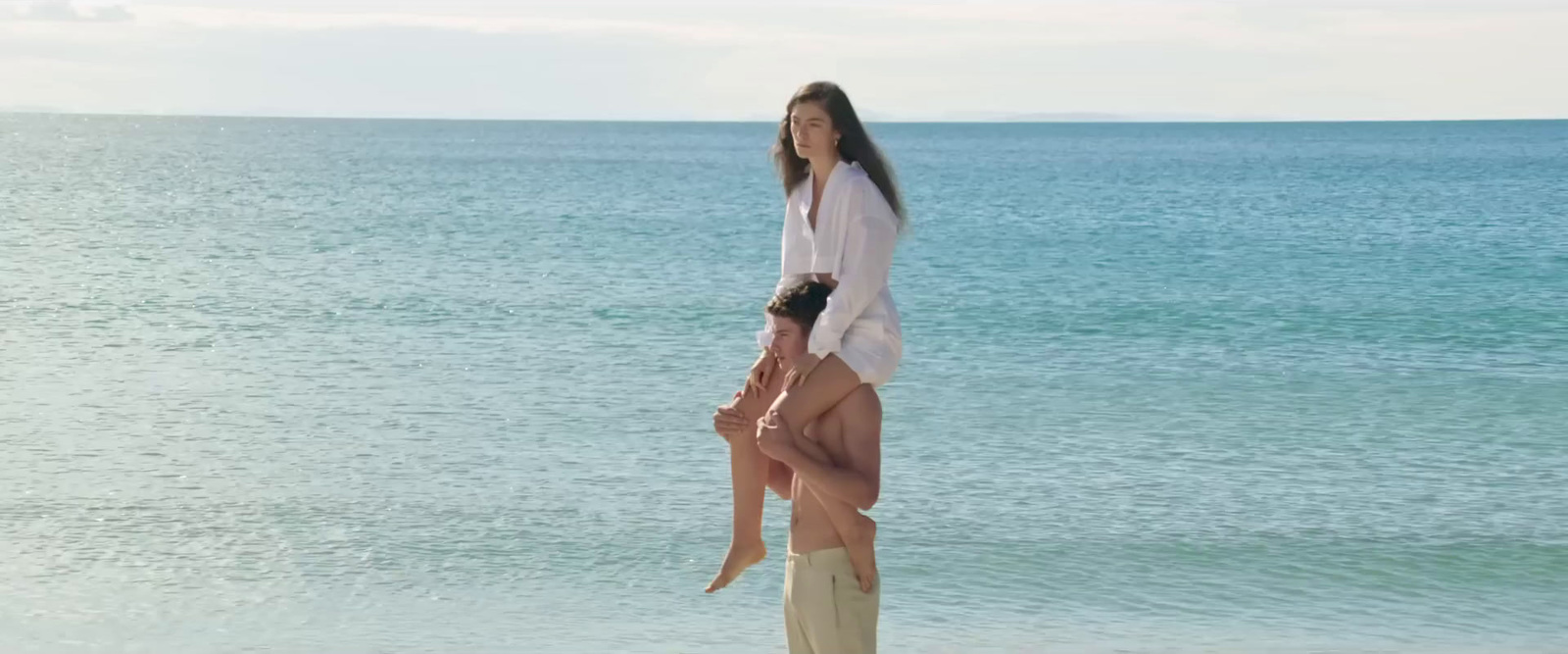 a woman standing on top of another woman on a beach