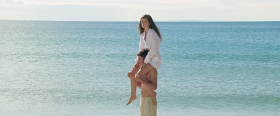 a woman standing on top of another woman on a beach