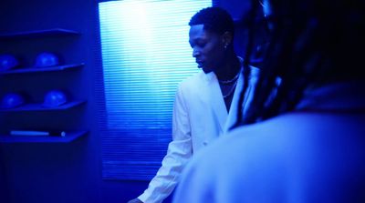 a woman standing in a room with blue lighting