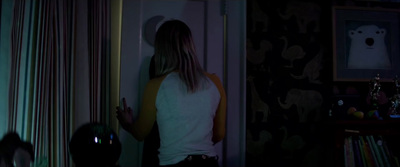 a woman standing in front of a door in a dark room