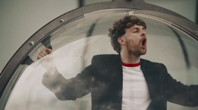 a man with his mouth open standing in front of a mirror