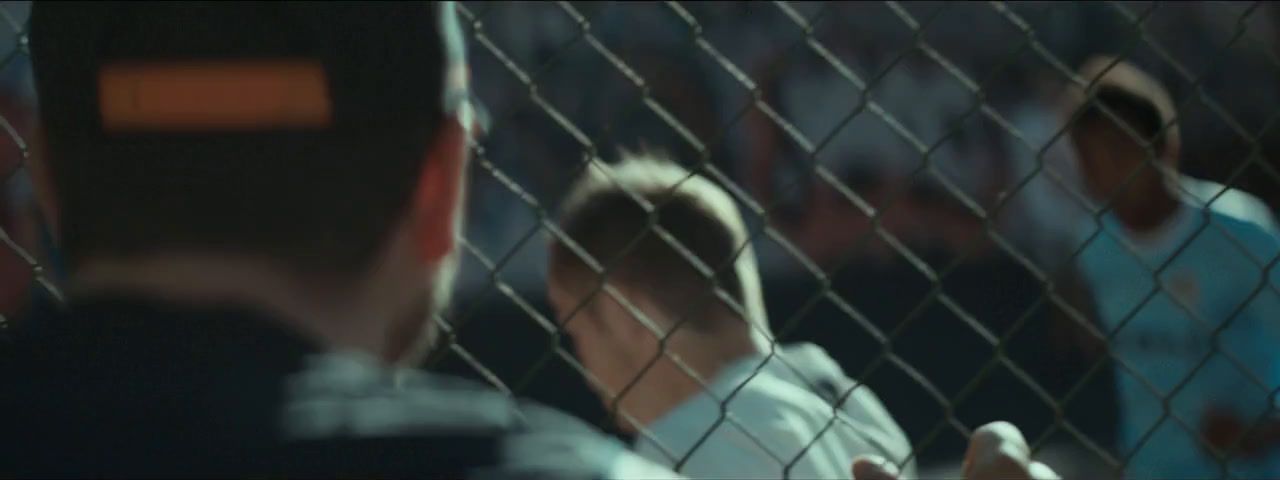 a group of people standing behind a chain link fence