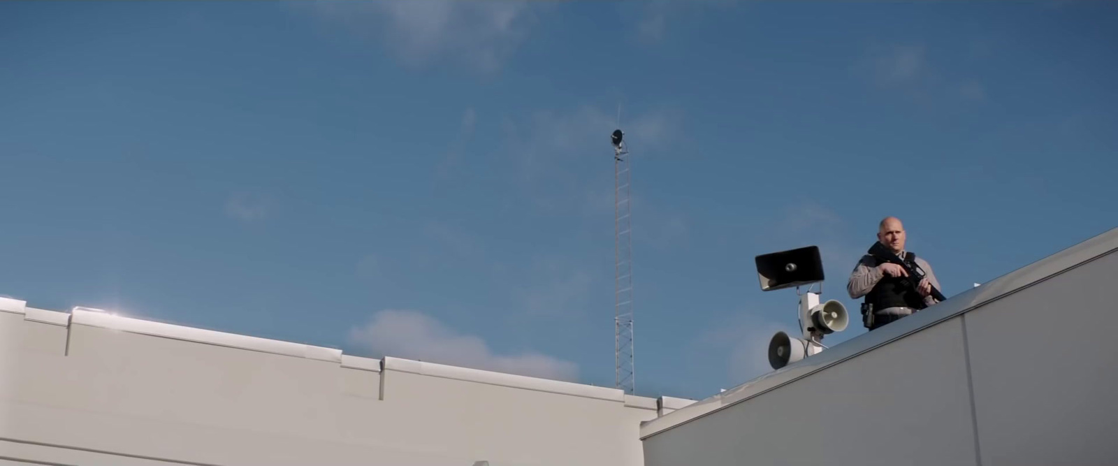 a man sitting on top of a roof with a laptop