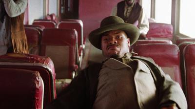 a man in a hat sitting on a bus