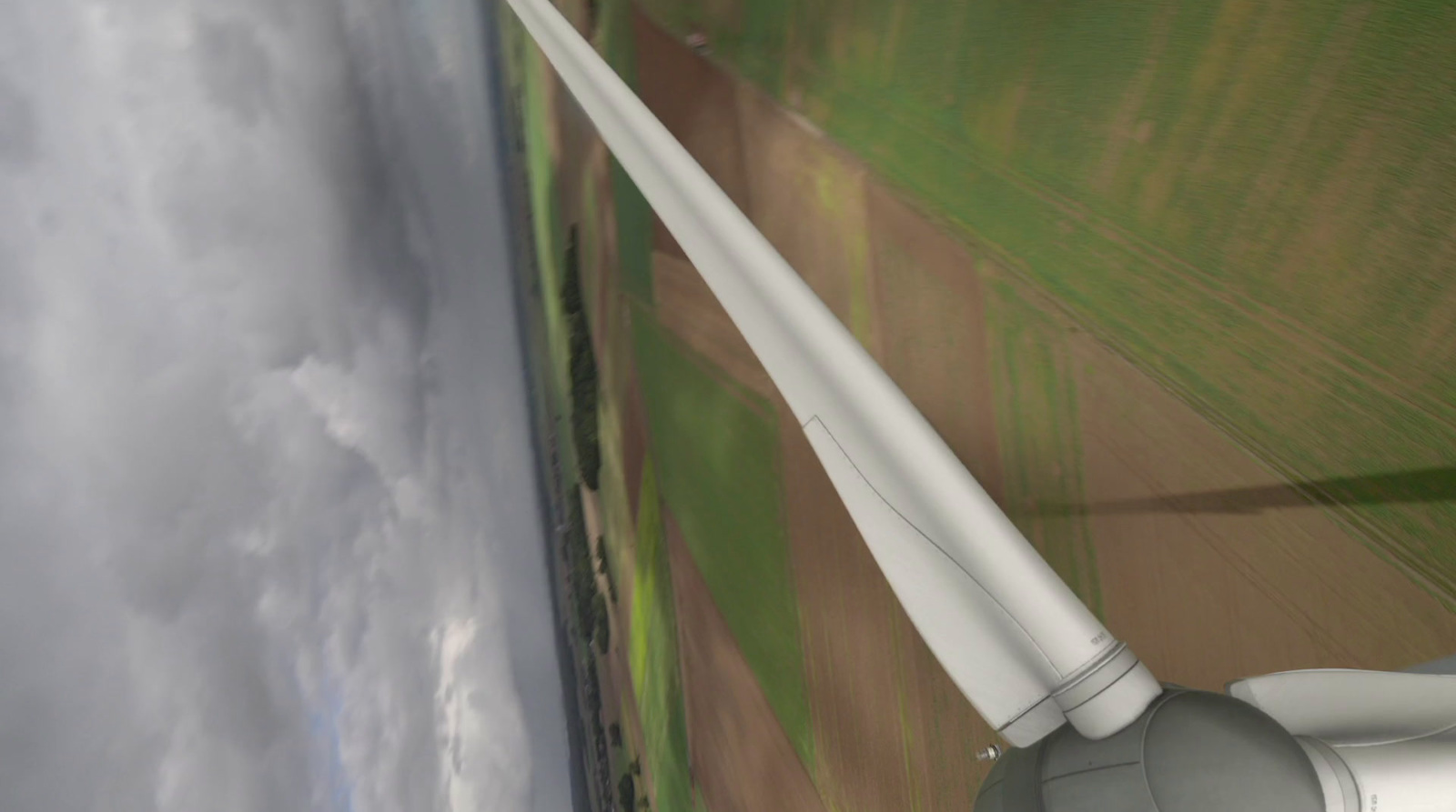 an aerial view of a wind turbine in a field