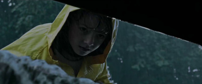 a woman in a yellow raincoat looking at something