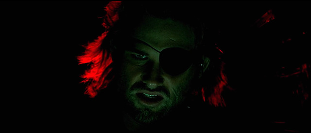 a man with long hair and sunglasses in the dark