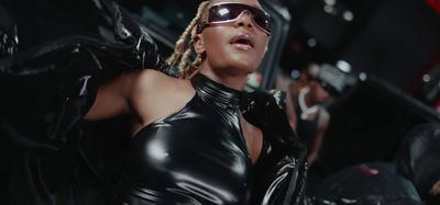 a woman in a black leather outfit and sunglasses