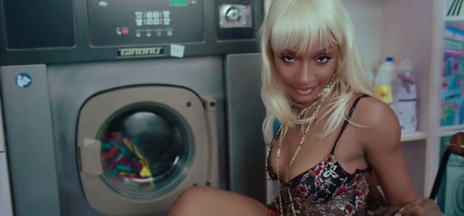 a woman in a bathing suit sitting next to a washing machine