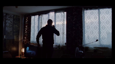 a man standing in front of a window in a living room