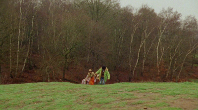 a group of people walking across a lush green field