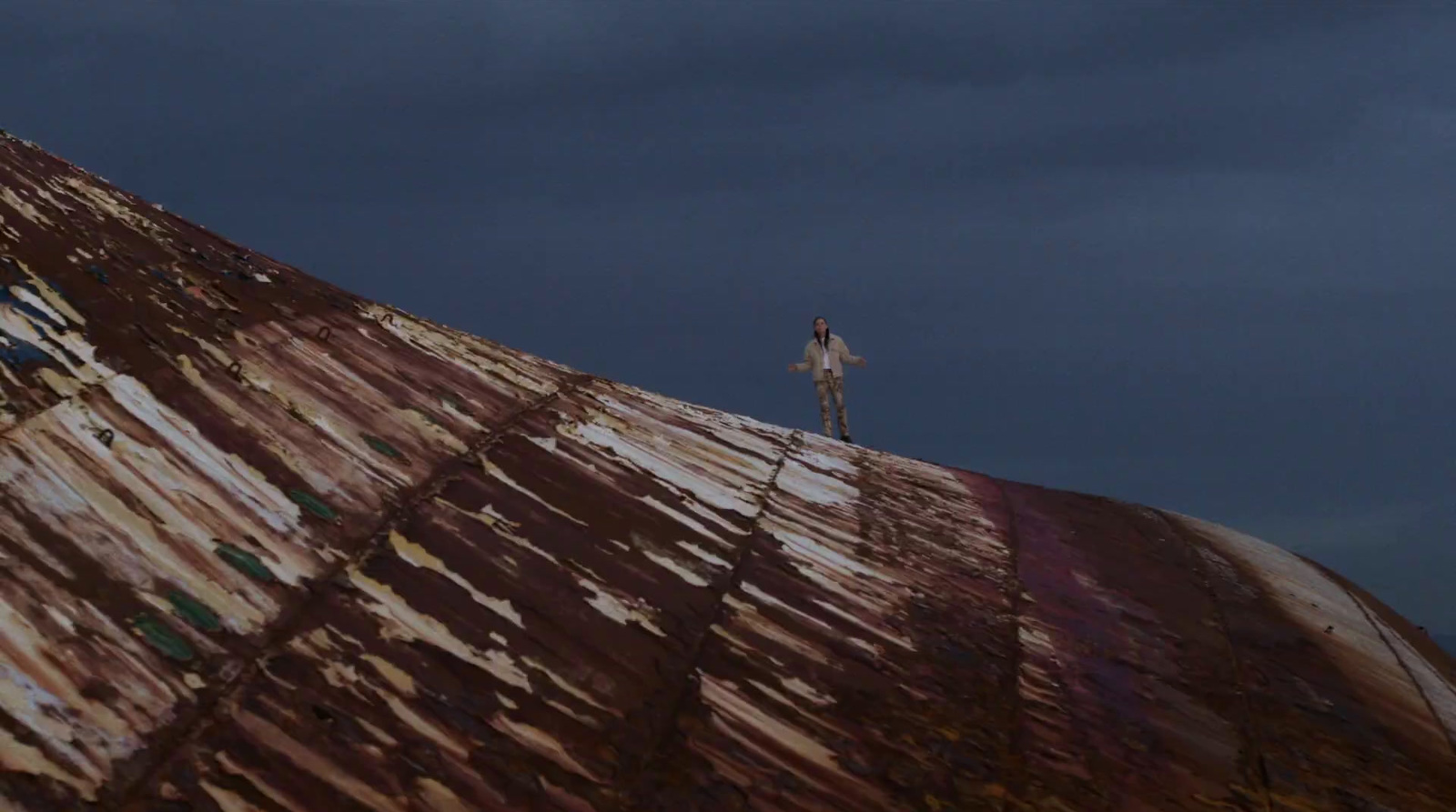 a man standing on top of a rusted metal structure