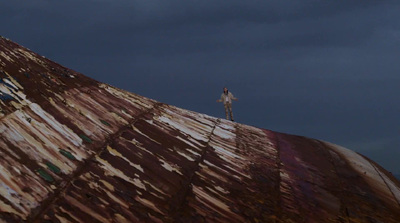 a man standing on top of a rusted metal structure