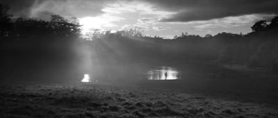 a black and white photo of the sun shining through the clouds