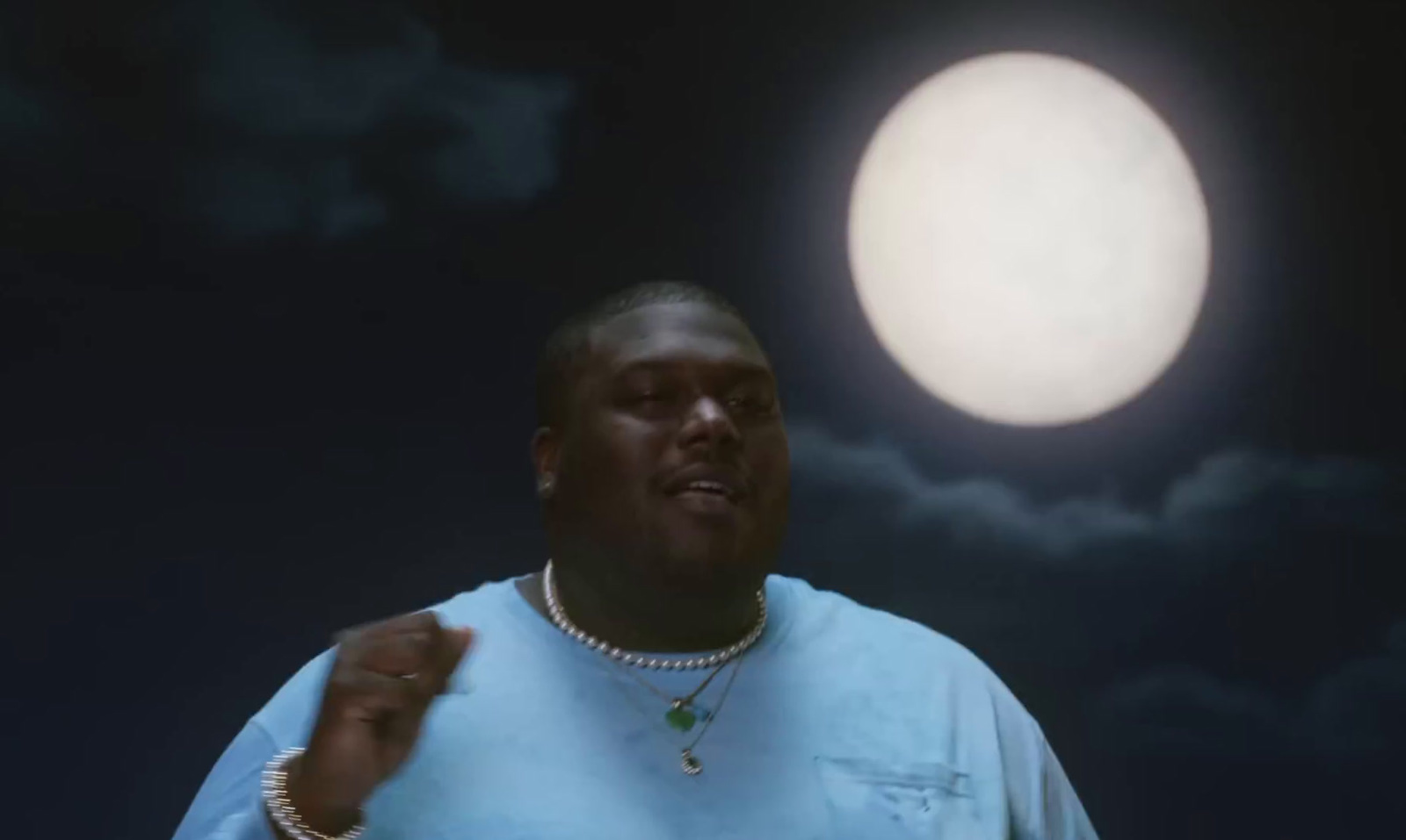 a man standing in front of a full moon