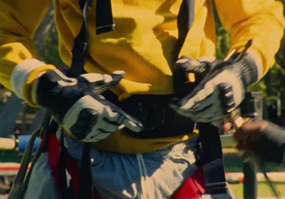 a man in yellow shirt holding a pair of gloves