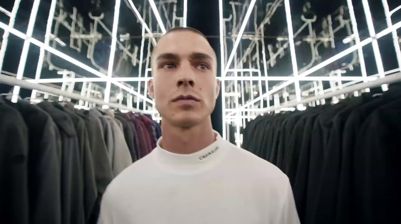 a man standing in front of a rack of clothes