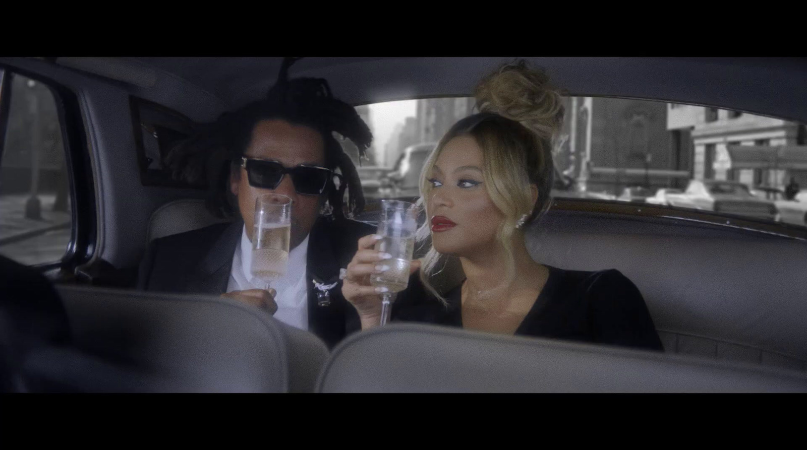 a man and a woman sitting in a car drinking wine