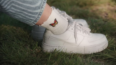 a close up of a person's foot with a butterfly on their shoe