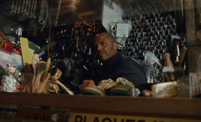 a man is sitting in a shop with many items