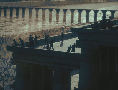 a group of people walking across a bridge over water