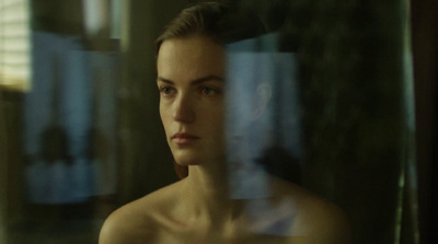 a woman looking out of a window with a blurry background