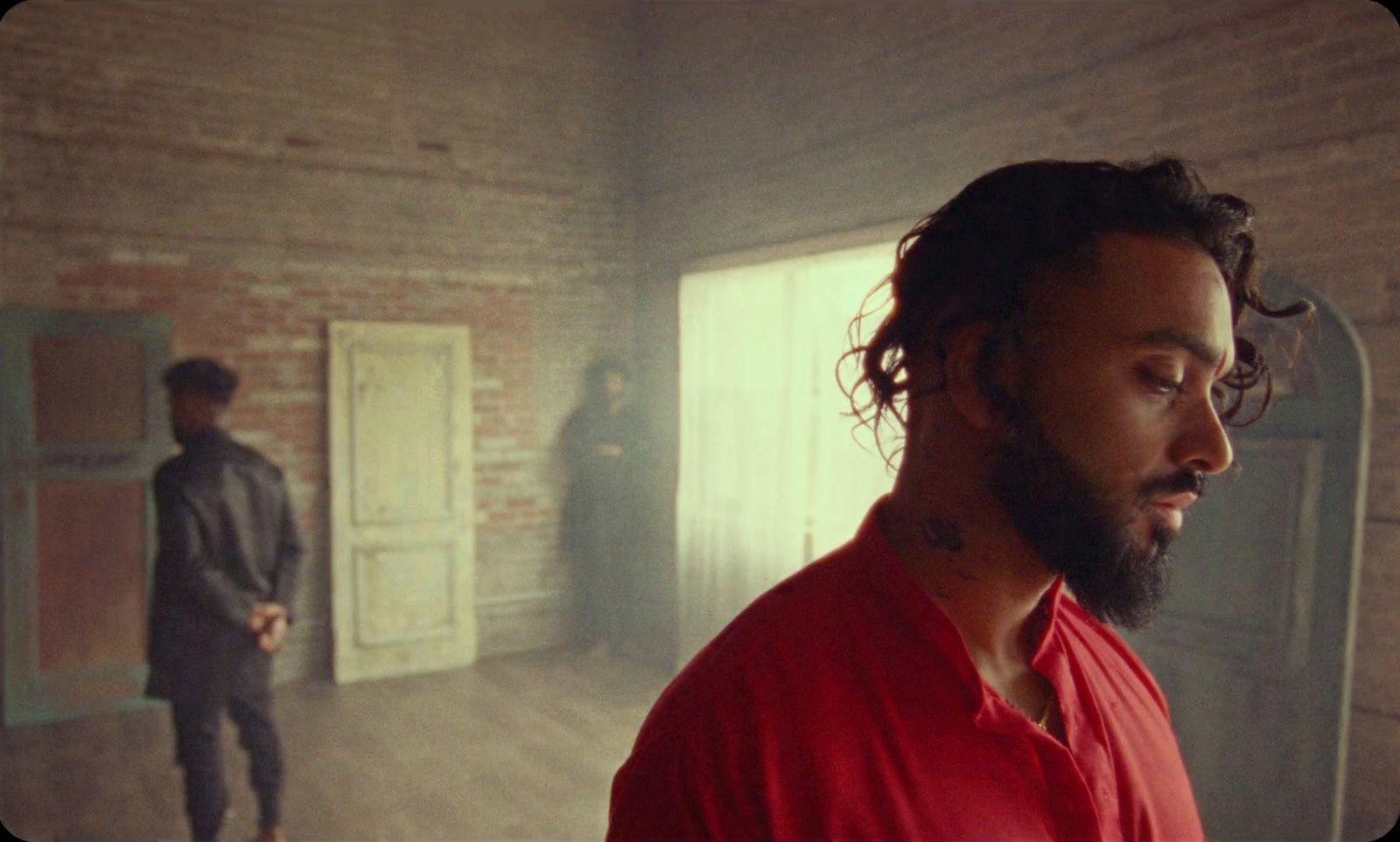 a man in a red shirt standing in a room