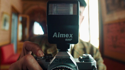 a person holding a camera with a lens attached to it