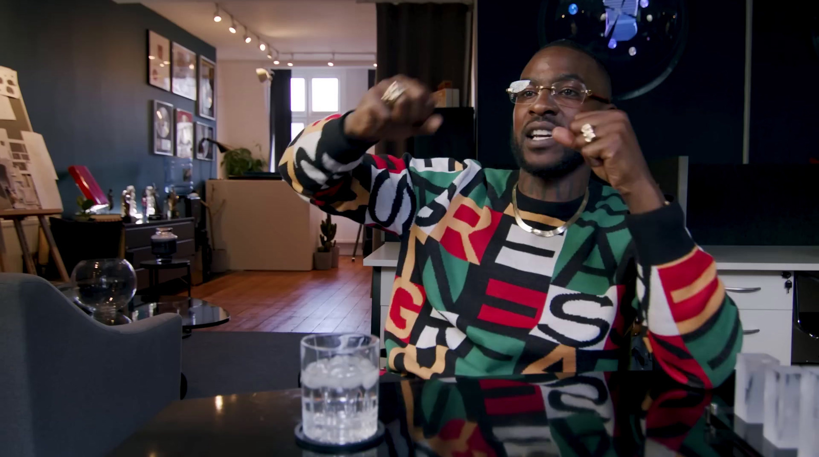 a man in a colorful sweater talking on a cell phone