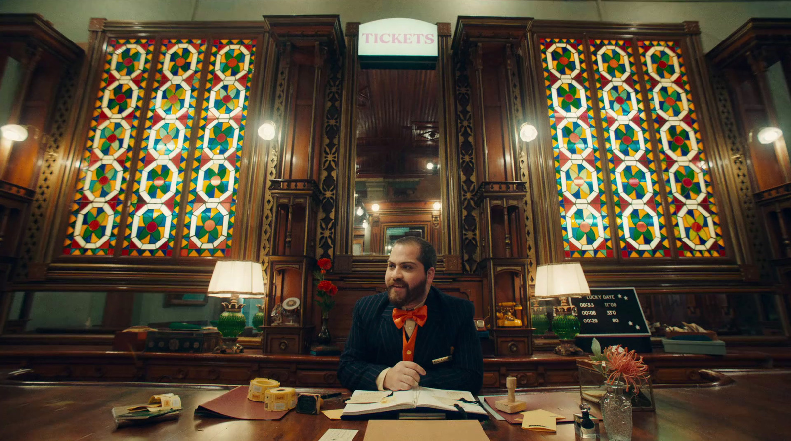 a man sitting at a desk in front of a stained glass window