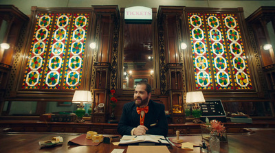 a man sitting at a desk in front of a stained glass window