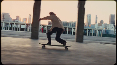 a man riding a skateboard down a sidewalk