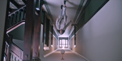 a person hanging upside down from a stair case