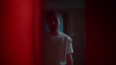 a man standing in front of a red wall