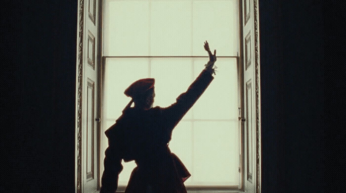 a person standing in front of a window with their arms in the air