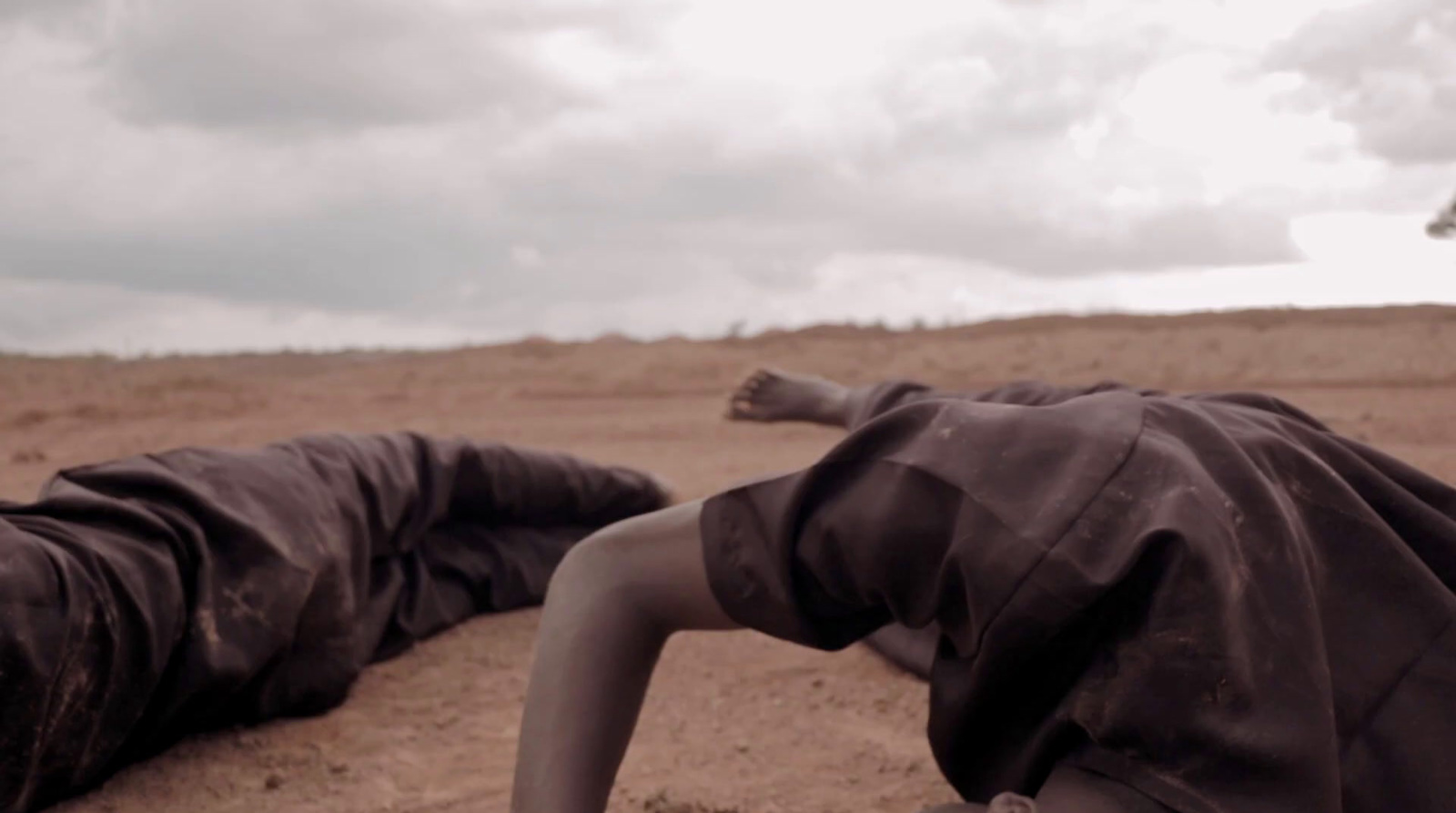 a person laying on the ground in the desert