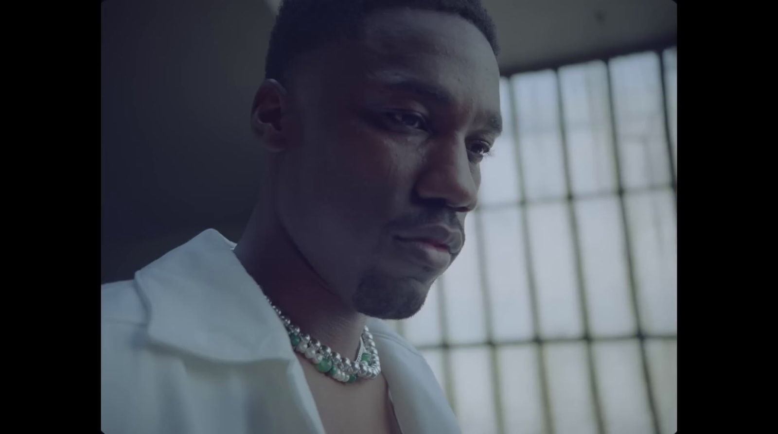 a man wearing a white shirt and a necklace