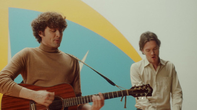 a man holding a guitar next to a man with a microphone