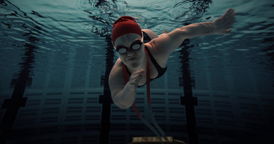 a woman swimming in a pool wearing a red hat and goggles