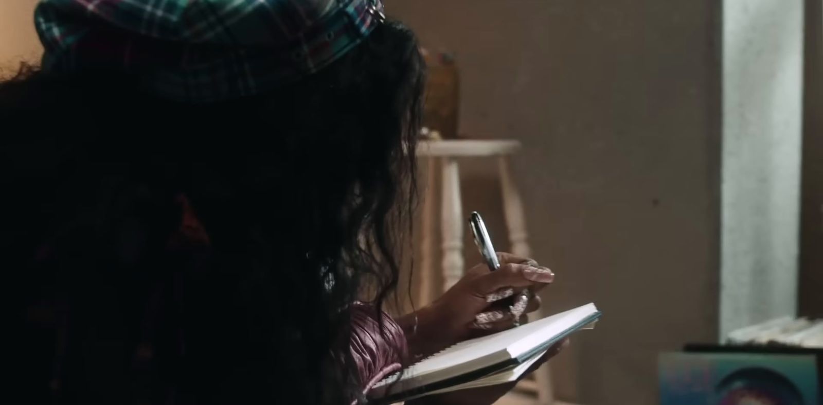 a woman holding a pen and writing in a notebook