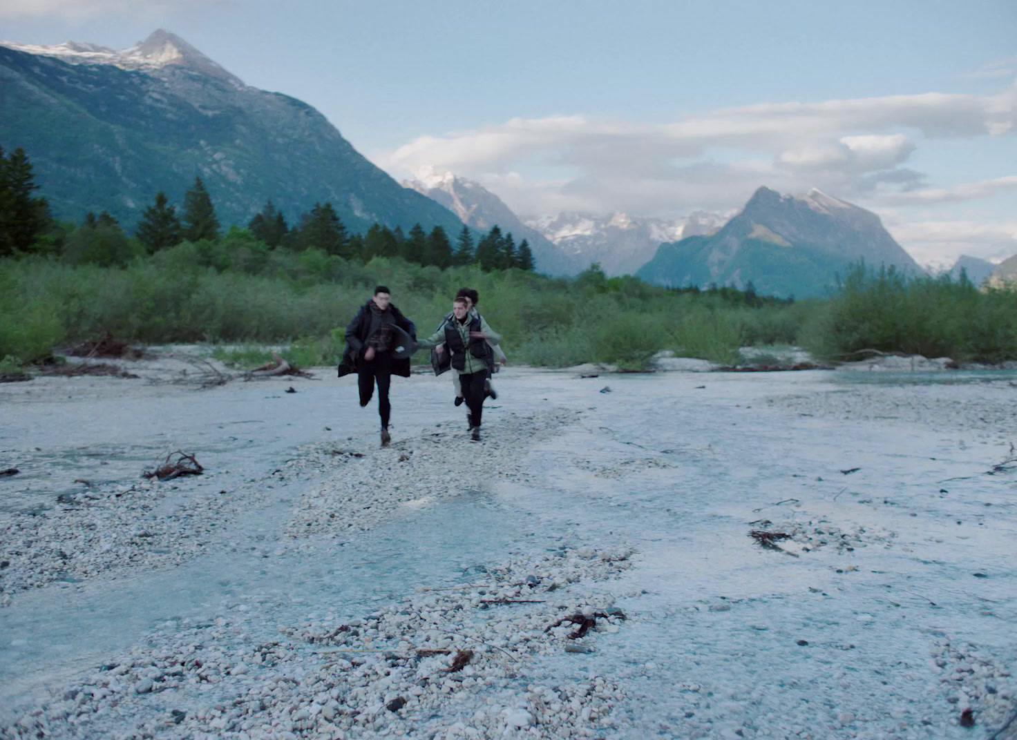 a couple of people walking across a river