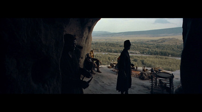 a group of people standing around a cave