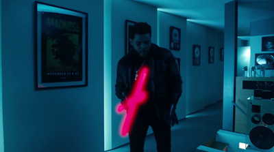 a man standing in a hallway holding a neon red object